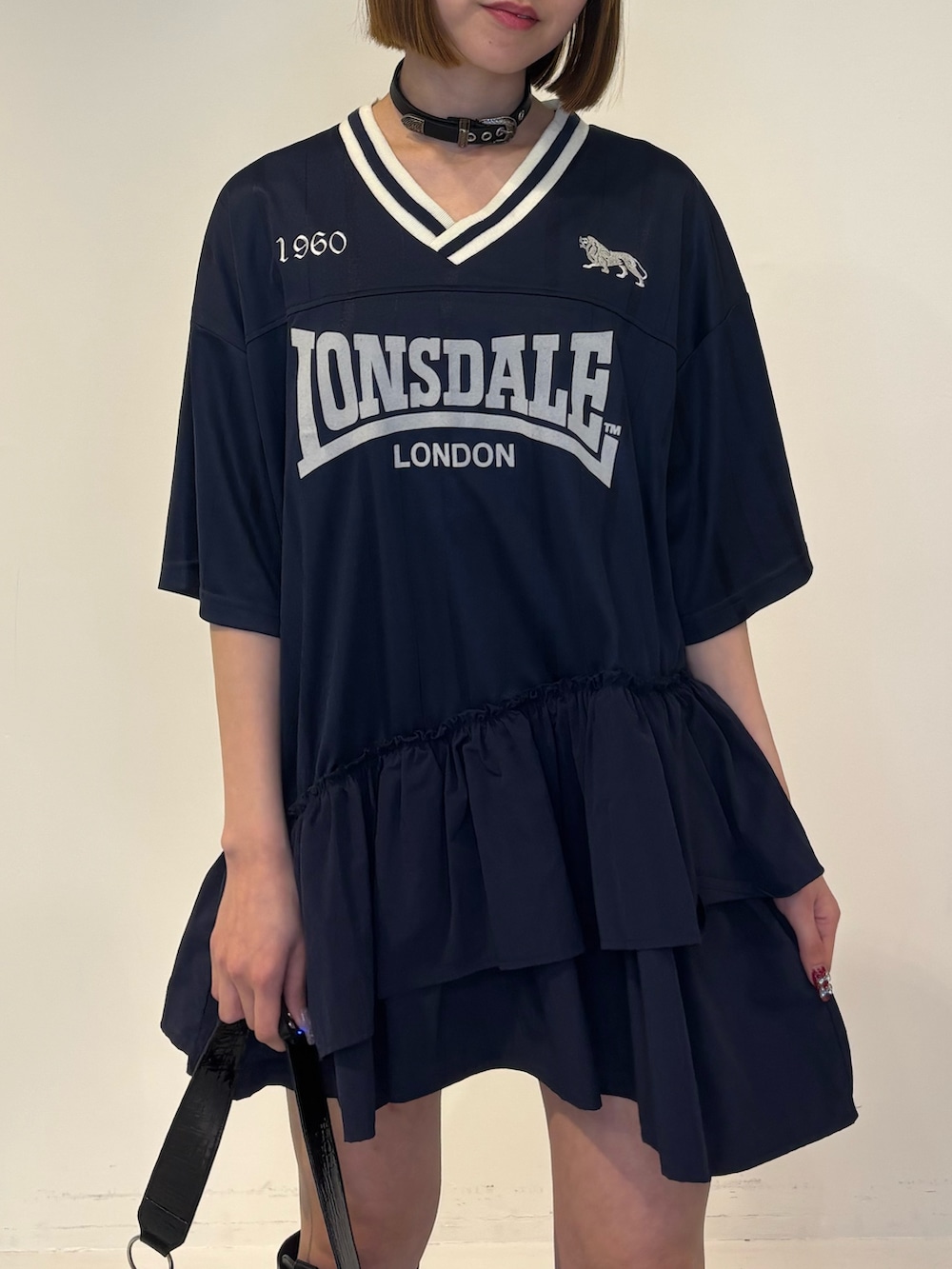 ブルー系のワンピース、ブラック系のハンドバッグ、ブラック系のブーツを着用したレディースの冬コーディネートの6枚目の写真