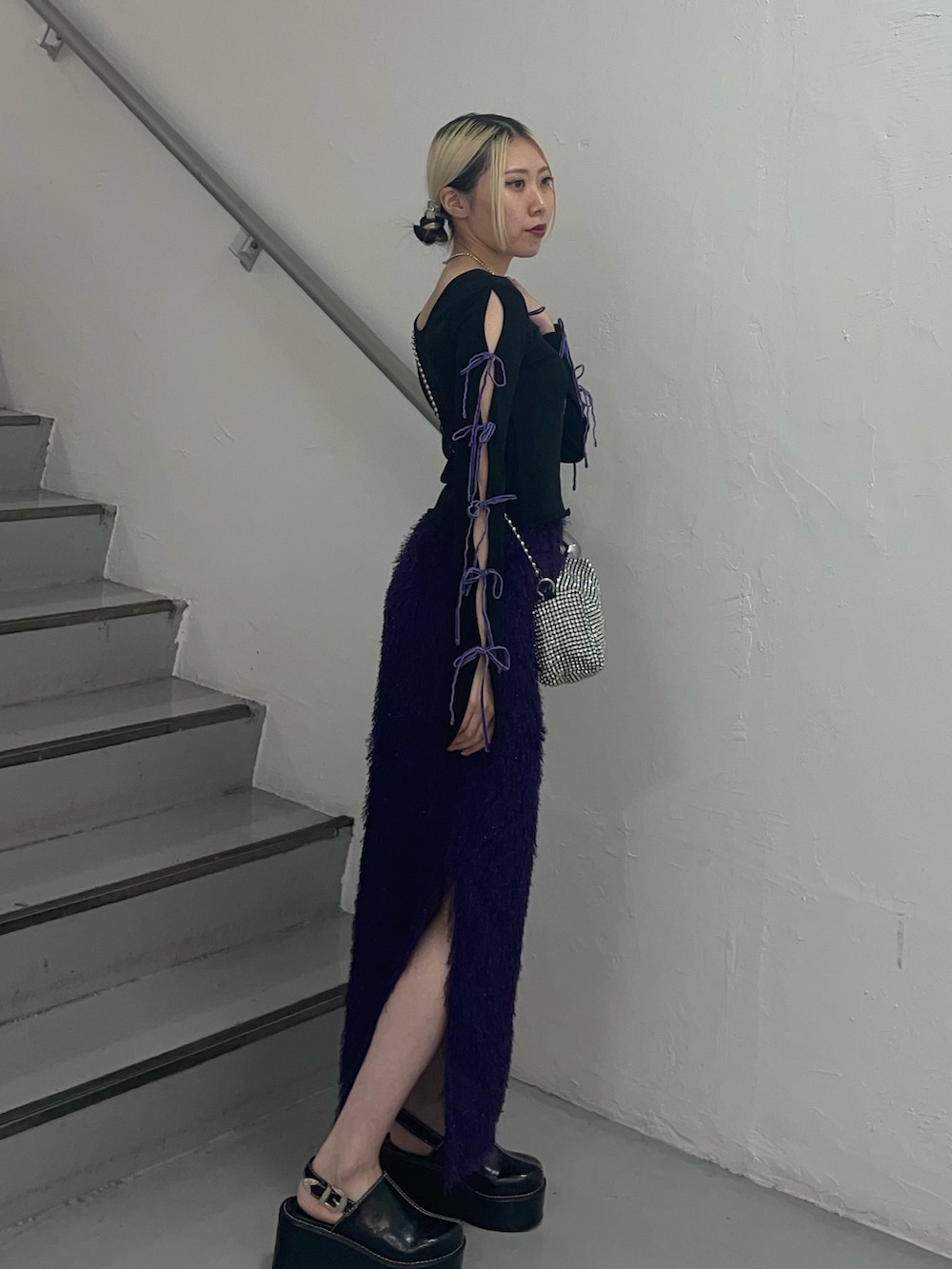 パープル系のスカート、ホワイト系のショルダーバッグ、ブラック系のTシャツ/カットソーを着用したレディースの夏コーディネートの3枚目の写真