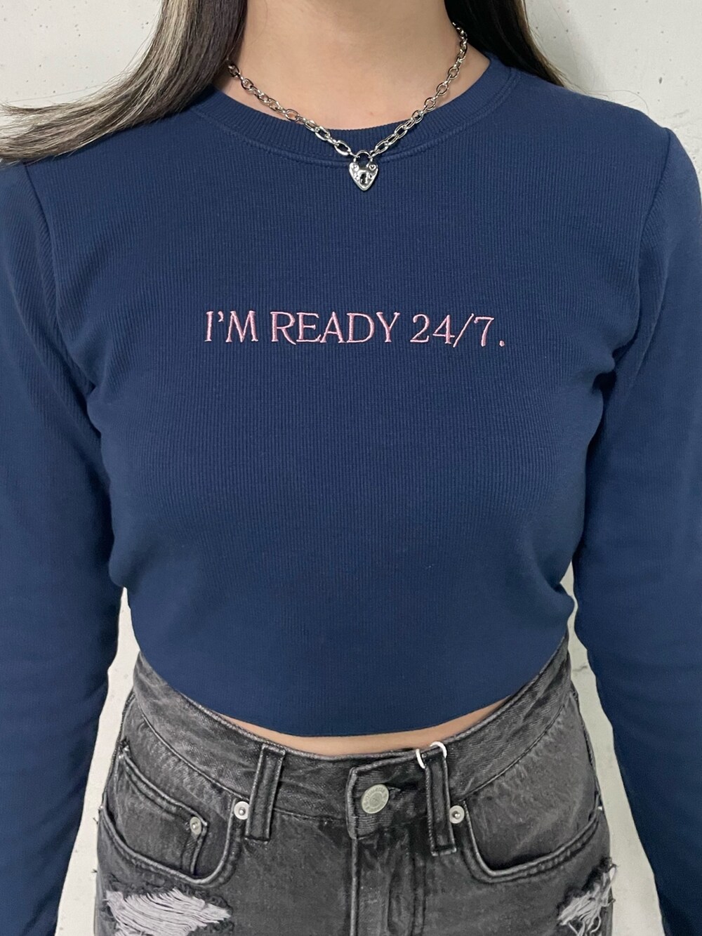 ブラック系のデニムスカート、ブラック系のTシャツ/カットソー、ブルー系のキャップを着用したレディースの冬コーディネートの7枚目の写真