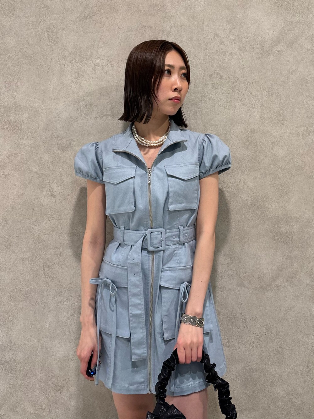 ブルー系のワンピース、ブラック系のハンドバッグ、ブラック系のローファーを着用したレディースの春コーディネートの5枚目の写真