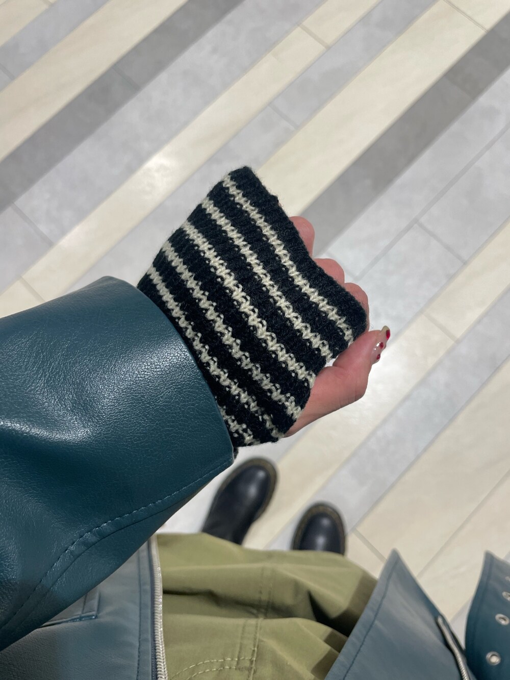 ホワイト系のTシャツ/カットソー、グリーン系のスカート、ブルー系のライダースジャケットを着用したレディースの秋コーディネートの9枚目の写真