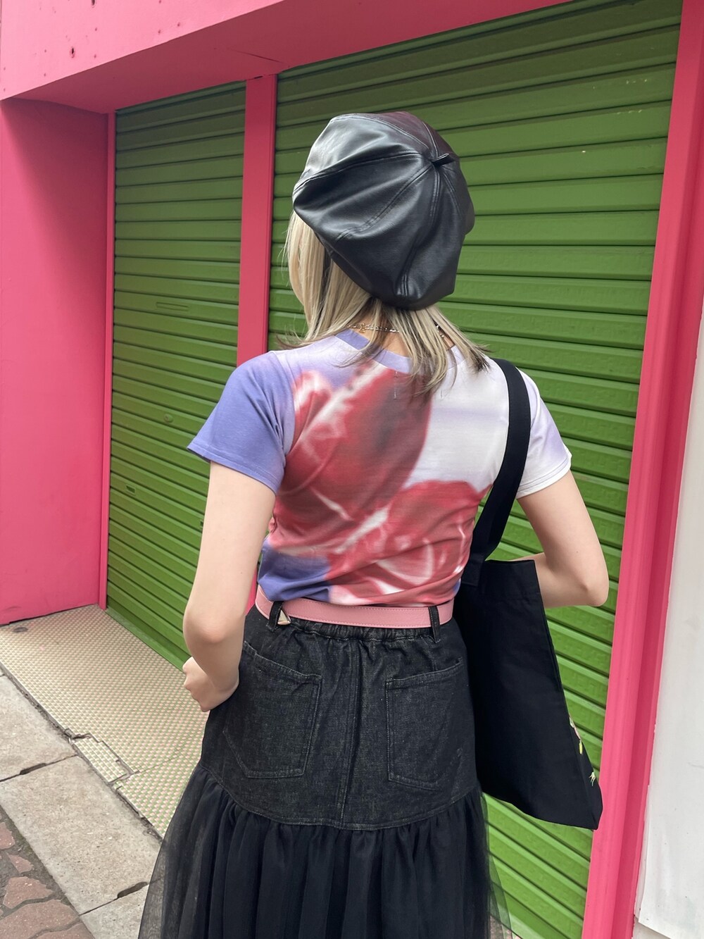ブラック系のスカート、ブラック系のトートバッグ、パープル系のTシャツ/カットソーを着用したレディースの春コーディネートの7枚目の写真