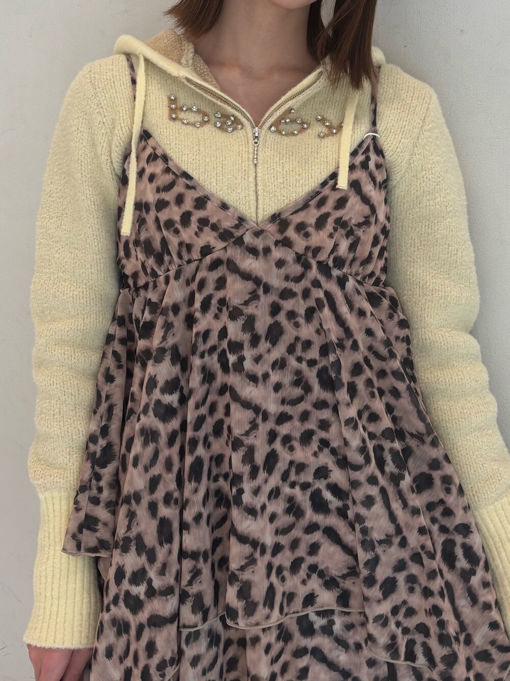 ブラウン系のワンピース、イエロー系のパーカー、ブラック系のブーツを着用したレディースの冬コーディネートの7枚目の写真