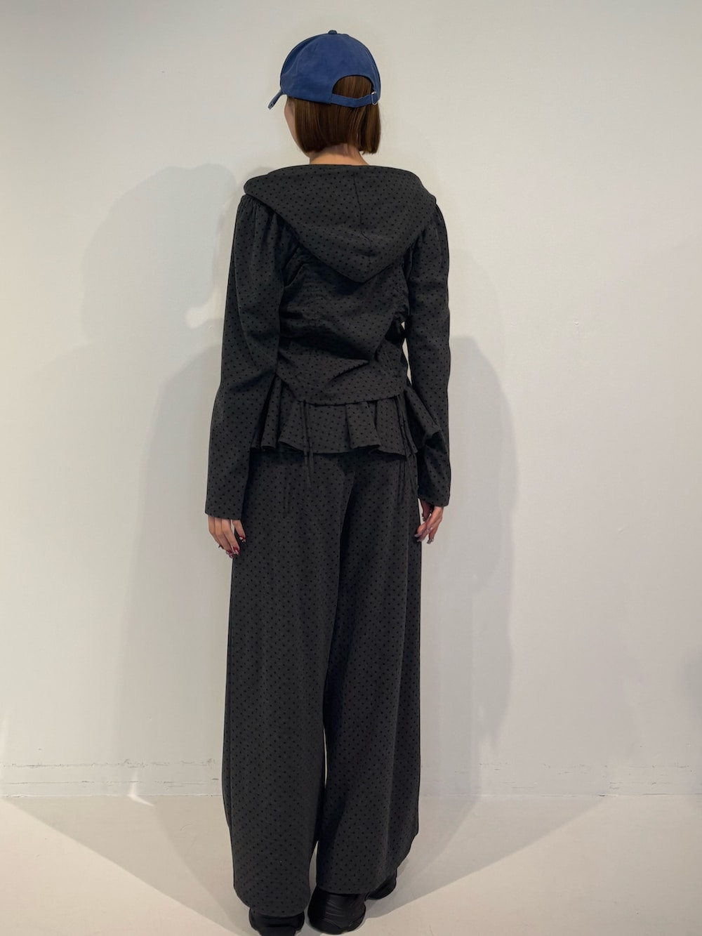 グレー系のスウェットパンツ、ブラック系のパーカー、ブラック系のローファーを着用したレディースの冬コーディネートの4枚目の写真