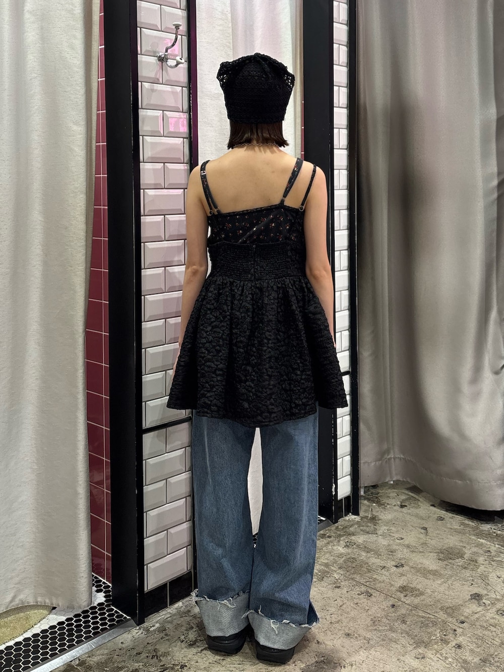 ブルー系のデニムパンツ、ブラック系のチュニック、レッド系のネックレスを着用したレディースの夏コーディネートの4枚目の写真