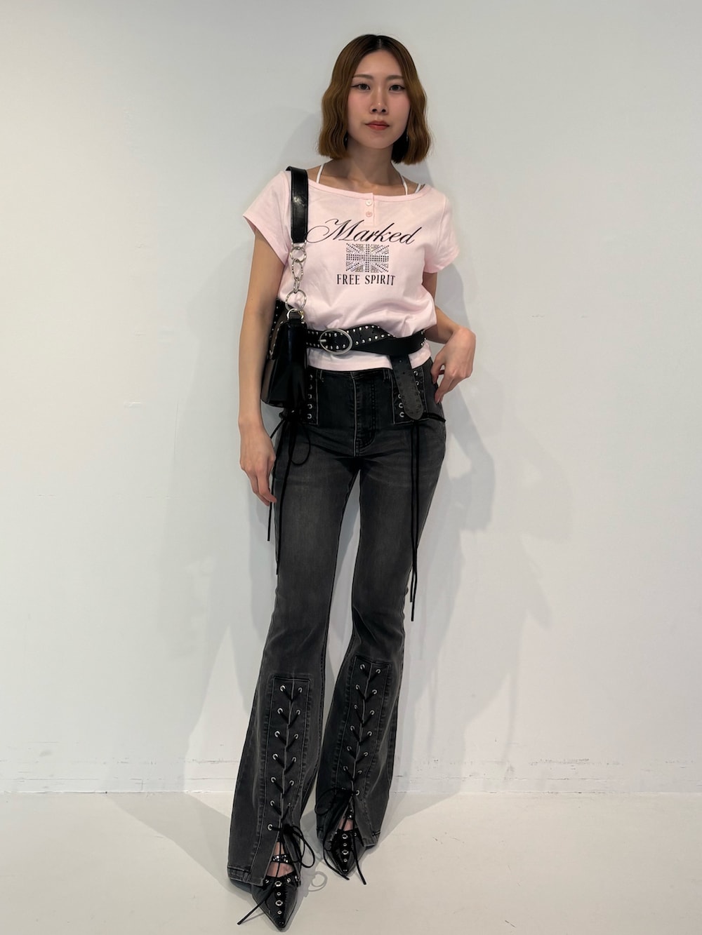 ブラック系のデニムパンツ、ブラック系のパンプス、ブラック系のハンドバッグを着用したレディースの春コーディネートの2枚目の写真