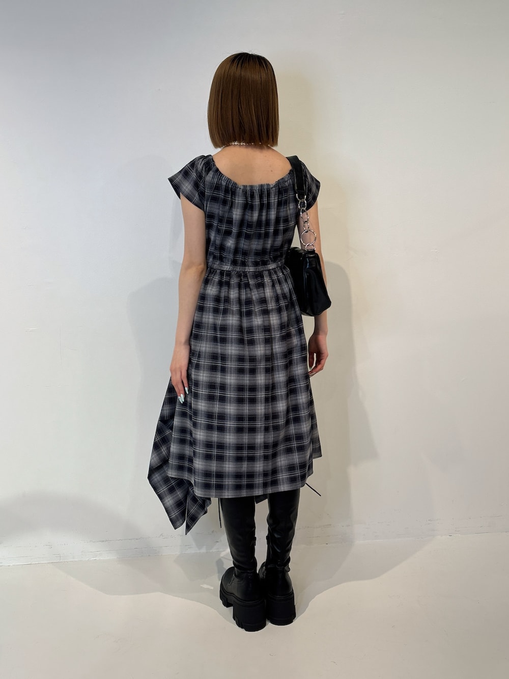 ブルー系のワンピース、ブラック系のブーツ、ブラック系のハンドバッグを着用したレディースの夏コーディネートの4枚目の写真