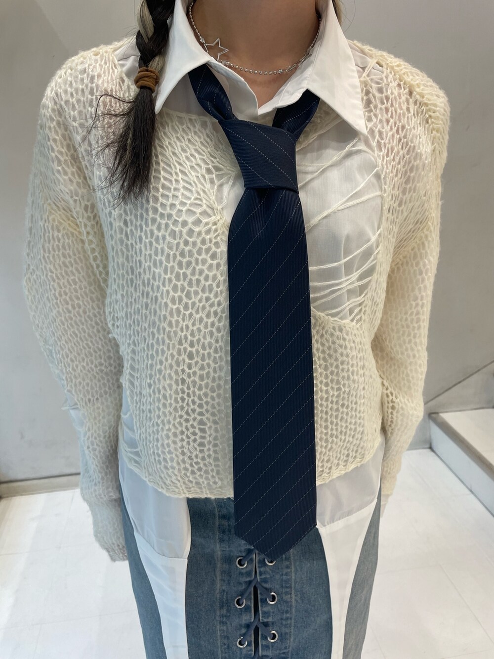 ホワイト系のニット/セーター、ホワイト系のシャツ/ブラウス、ブルー系のデニムパンツを着用したレディースの秋コーディネートの7枚目の写真