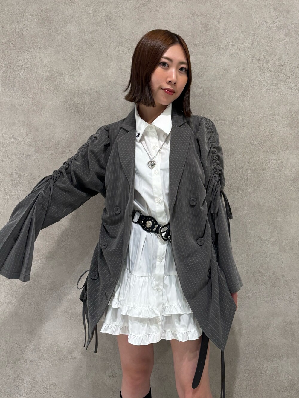 ホワイト系のワンピース、ブラック系のパンプス、グレー系のテーラードジャケットを着用したレディースの夏コーディネートの6枚目の写真