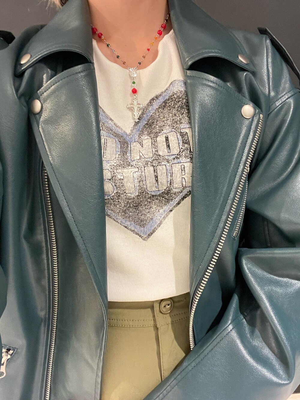 ホワイト系のTシャツ/カットソー、グリーン系のスカート、ブルー系のライダースジャケットを着用したレディースの秋コーディネートの7枚目の写真