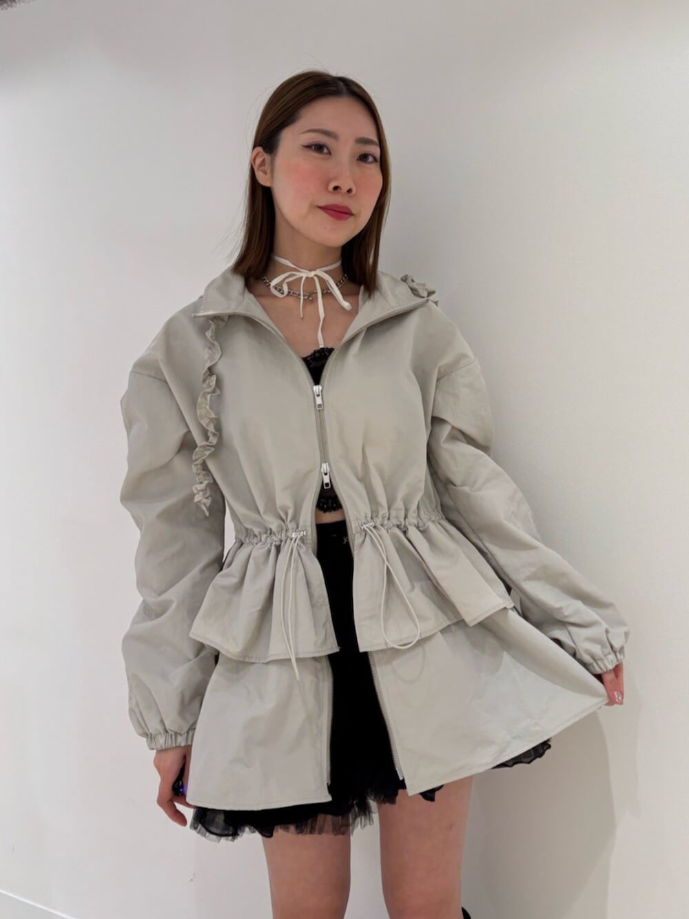 ブラウン系のブーツ、レッド系のスカート、ホワイト系のナイロンジャケットを着用したレディースの冬コーディネートの6枚目の写真