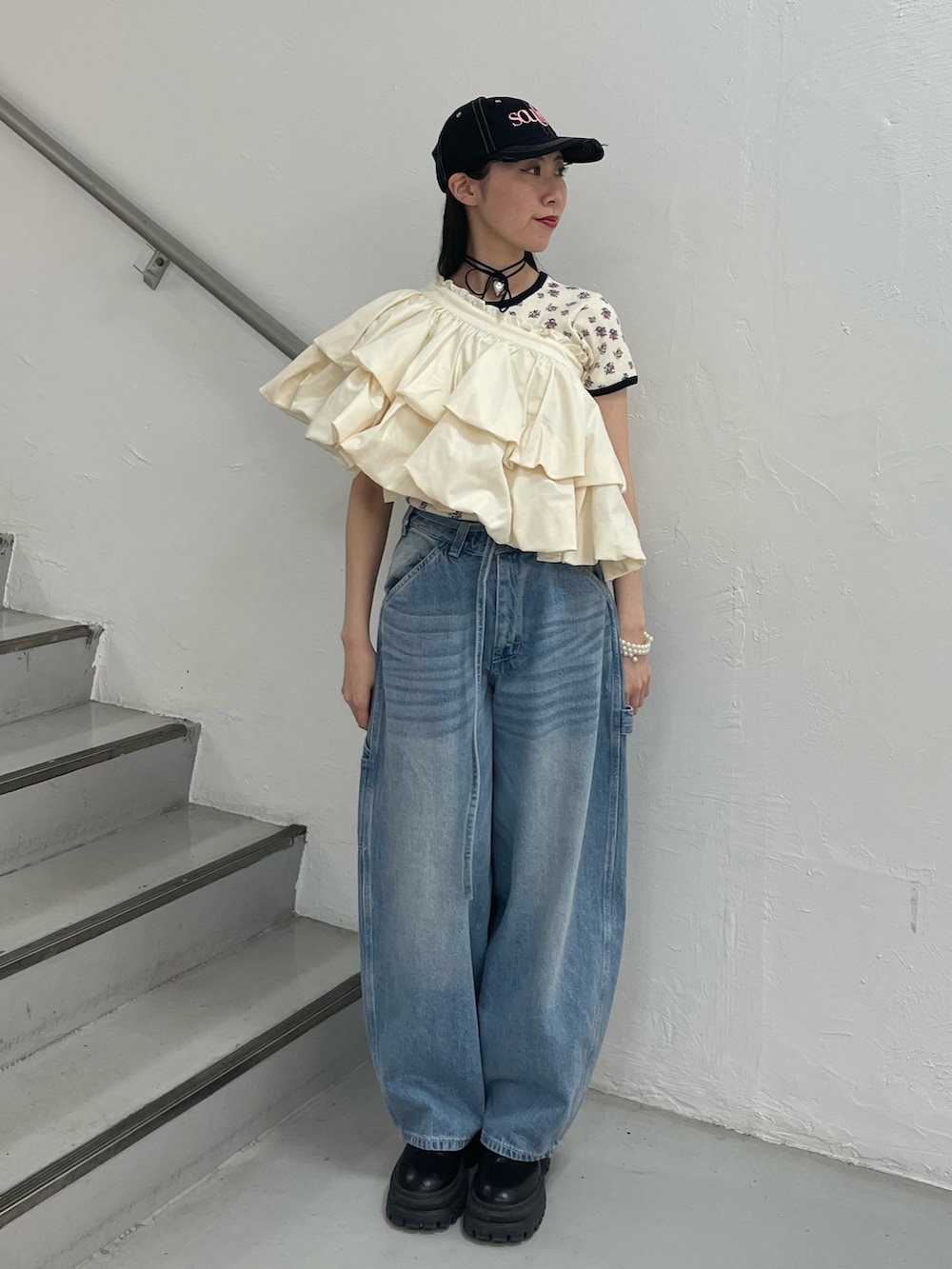 ブルー系のデニムパンツ、ホワイト系のスカート、ホワイト系のTシャツ/カットソーを着用したレディースの春コーディネートの2枚目の写真