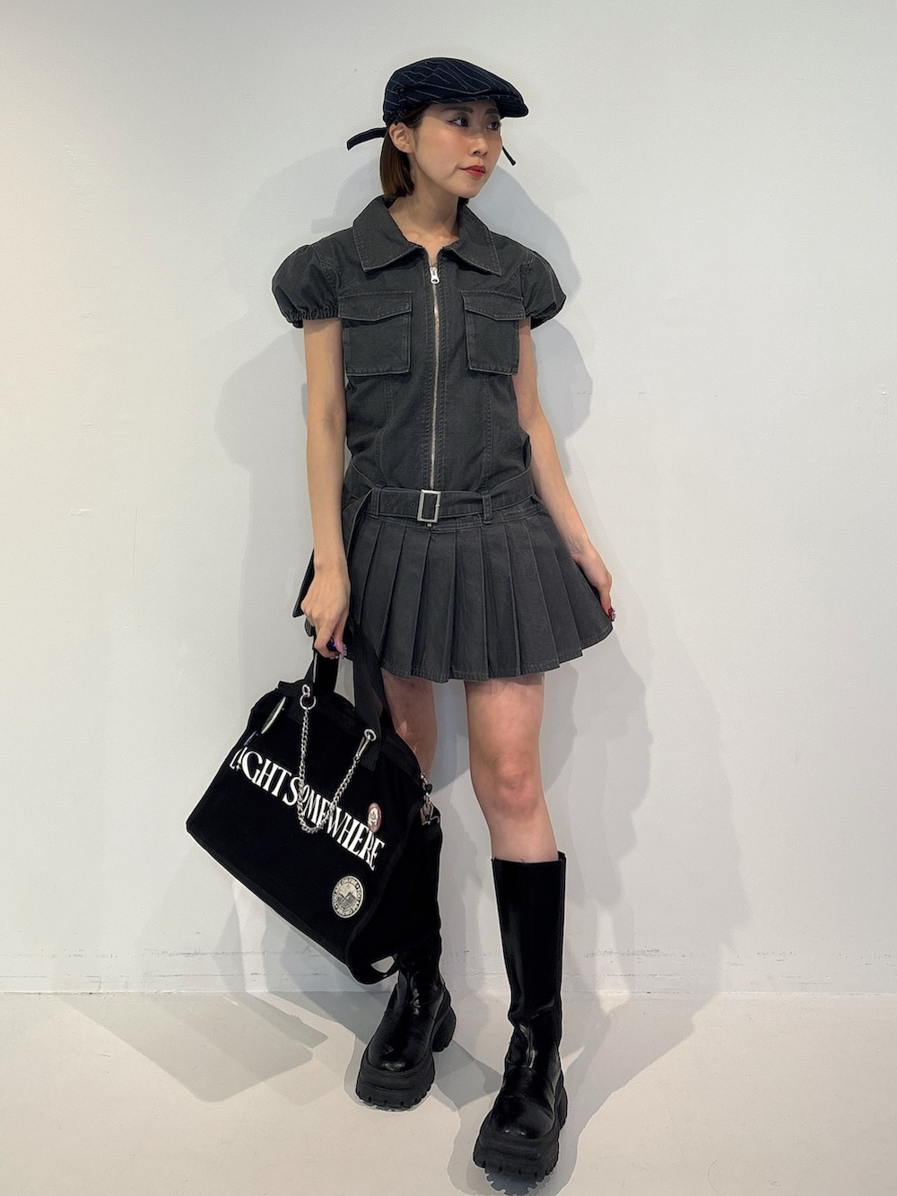 ブラック系のワンピース、ブラック系のボストンバッグ、ブルー系のハンチング/ベレー帽を着用したレディースの冬コーディネートの2枚目の写真