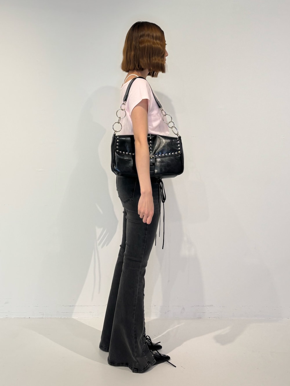 ブラック系のデニムパンツ、ブラック系のパンプス、ブラック系のハンドバッグを着用したレディースの春コーディネートの3枚目の写真