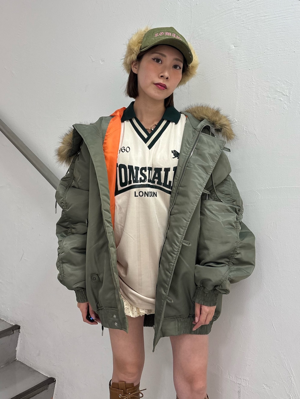 ホワイト系のTシャツ/カットソー、ホワイト系のスカート、グリーン系のブルゾンを着用したレディースの秋コーディネートの7枚目の写真