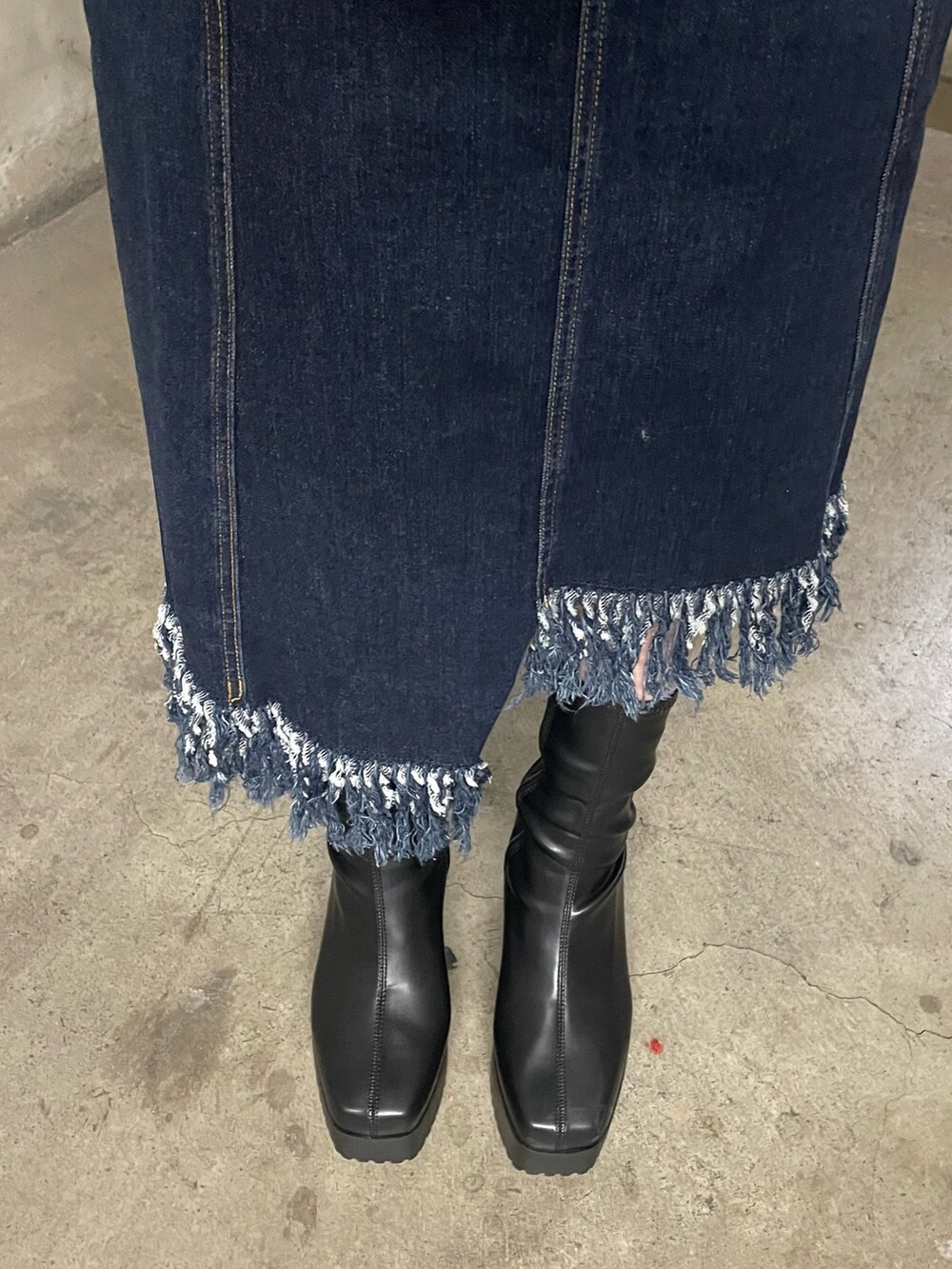 グレー系のスウェット、ブルー系のジャンパースカート、ブラック系のブーツを着用したレディースの冬コーディネートの8枚目の写真