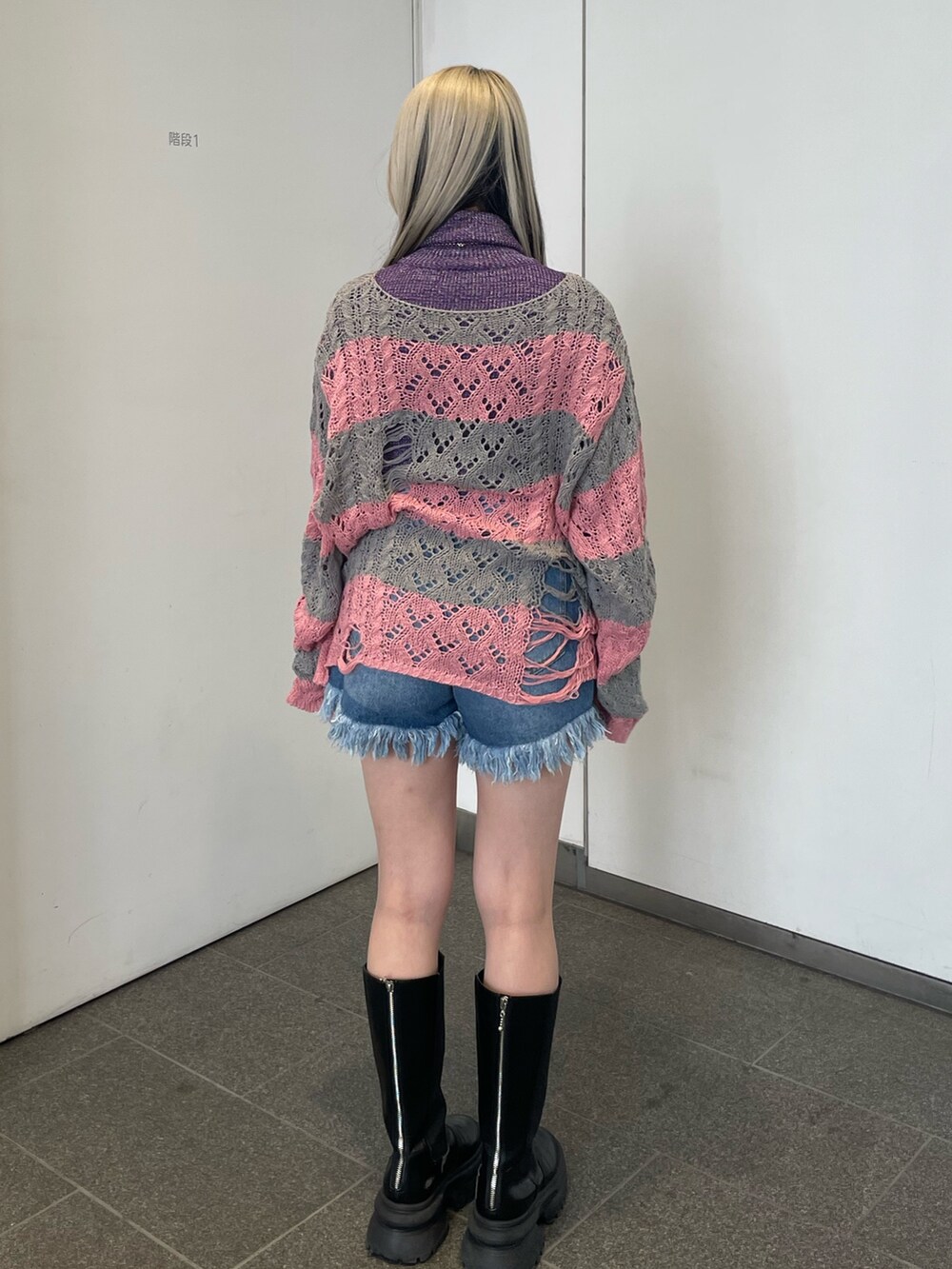 ピンク系のニット/セーター、パープル系のニット/セーター、ブルー系のデニムパンツを着用したレディースの冬コーディネートの4枚目の写真