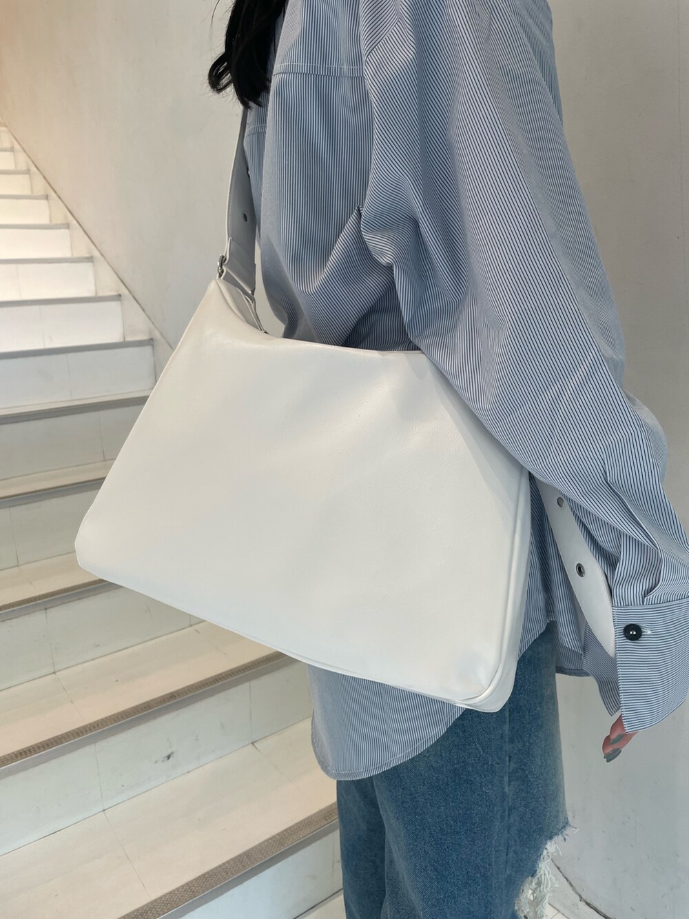 ブルー系のシャツ/ブラウス、シルバー系のショルダーバッグ、ブルー系のデニムパンツを着用したレディースの春コーディネートの8枚目の写真