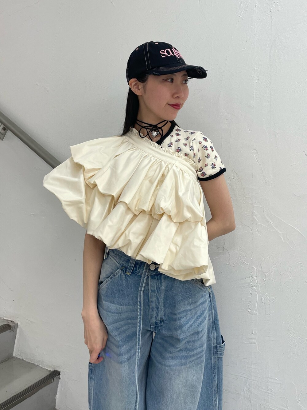 ブルー系のデニムパンツ、ホワイト系のスカート、ホワイト系のTシャツ/カットソーを着用したレディースの春コーディネートの5枚目の写真