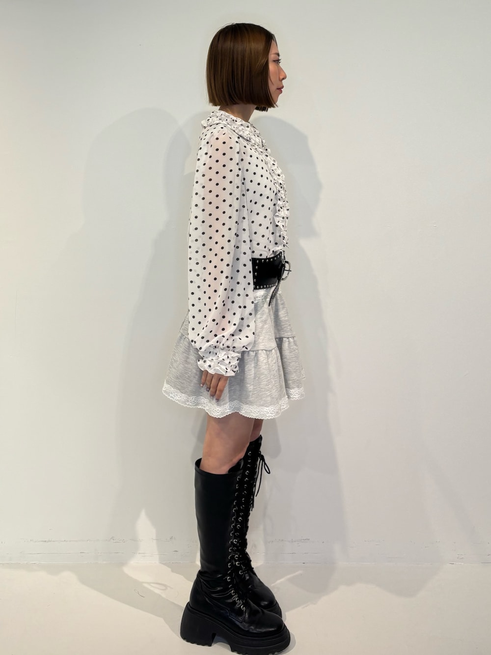 ホワイト系のシャツ/ブラウス、グレー系のワンピース、ブラック系のブーツを着用したレディースの冬コーディネートの3枚目の写真