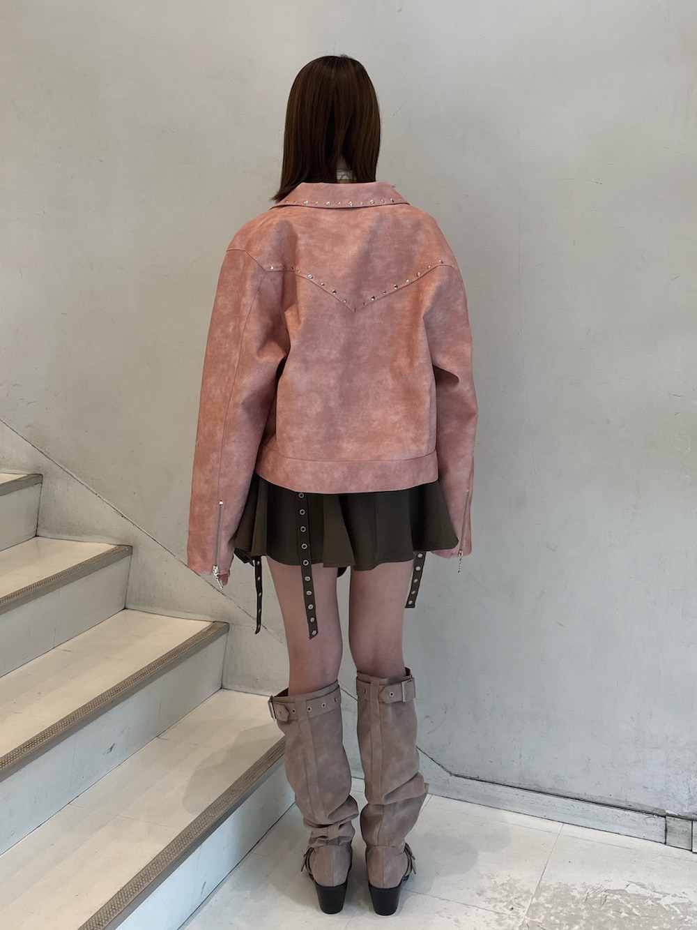 ベージュ系のスカート、ピンク系のブーツ、ピンク系のブルゾンを着用したレディースの冬コーディネートの4枚目の写真