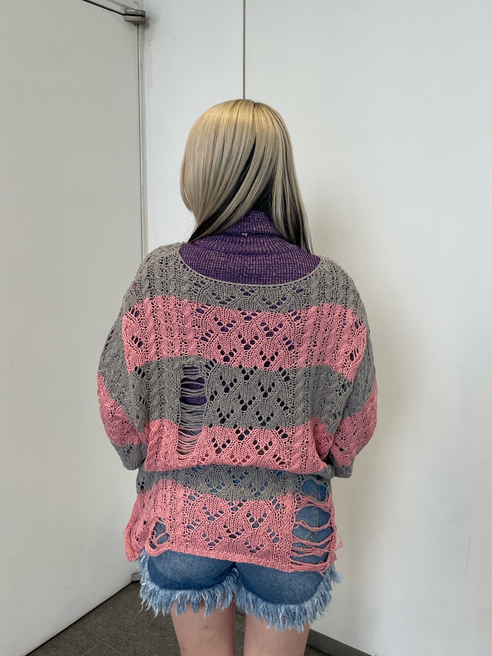 ピンク系のニット/セーター、パープル系のニット/セーター、ブルー系のデニムパンツを着用したレディースの冬コーディネートの7枚目の写真