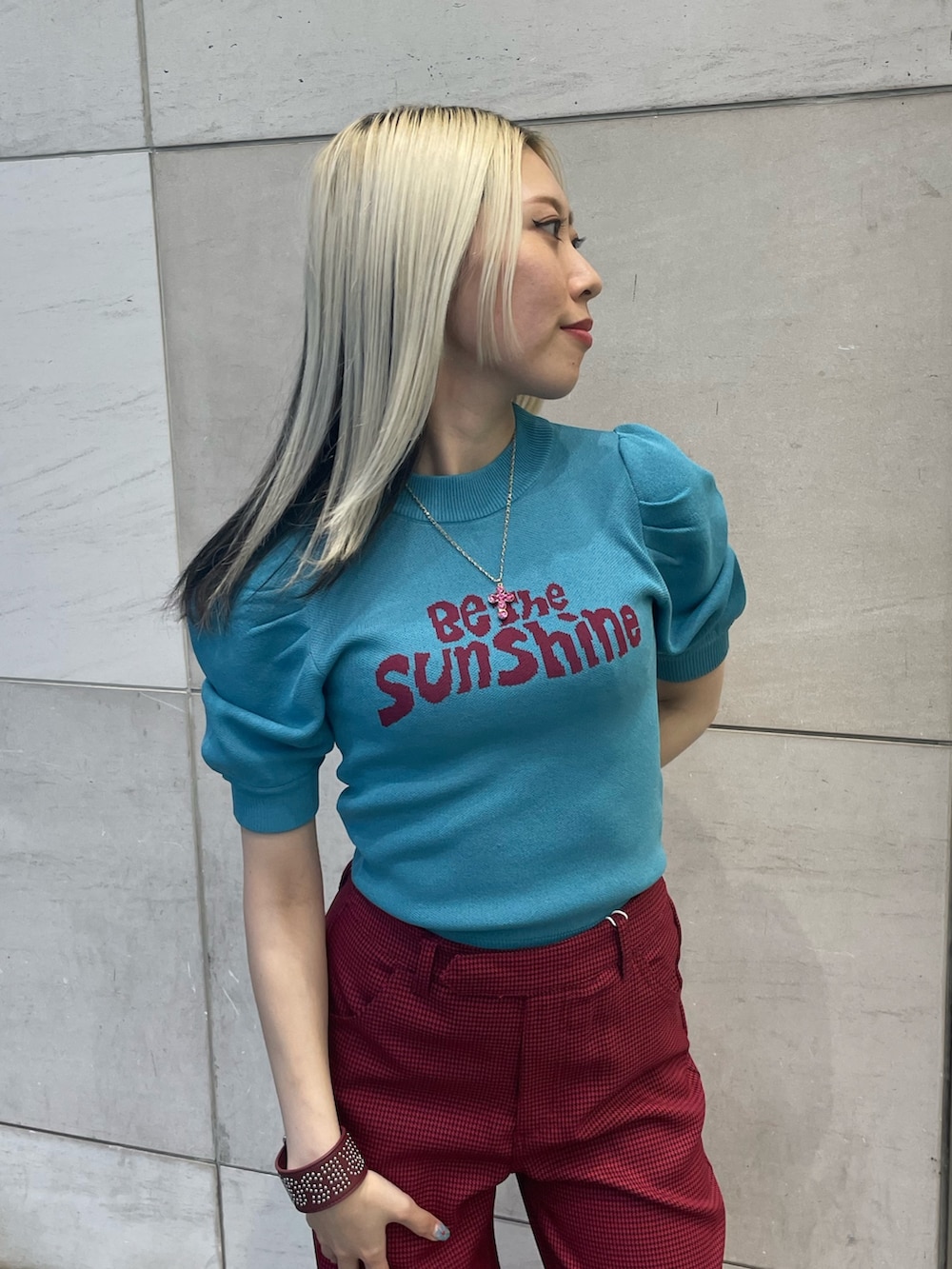 ブルー系のニット/セーター、レッド系のその他パンツ、レッド系のブレスレットを着用したレディースの夏コーディネートの4枚目の写真