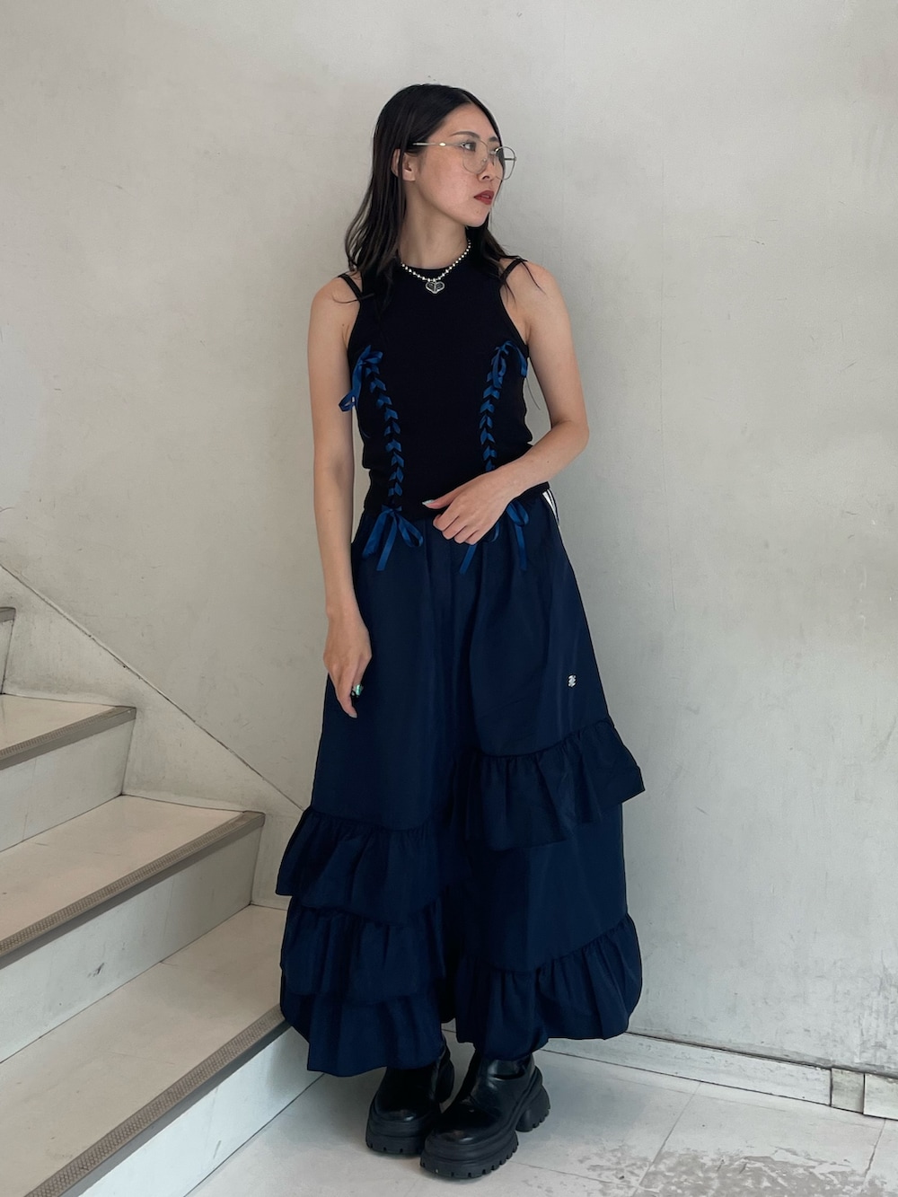 ブルー系のスカート、ブラック系のタンクトップ、ブラック系のキャミソールを着用したレディースの夏コーディネートの2枚目の写真