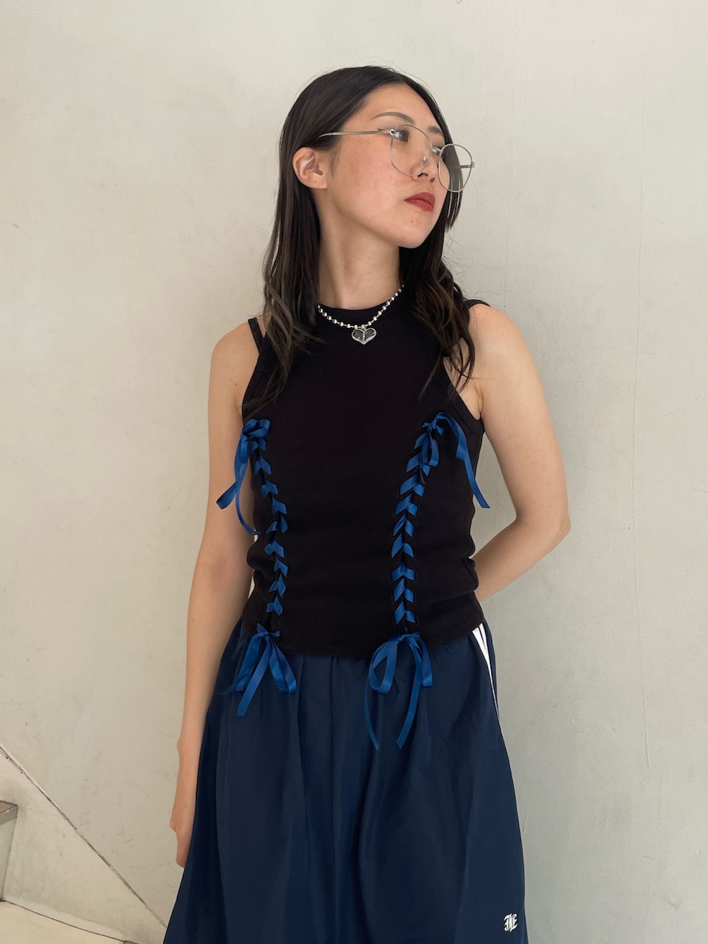 ブルー系のスカート、ブラック系のタンクトップ、ブラック系のキャミソールを着用したレディースの夏コーディネートの7枚目の写真