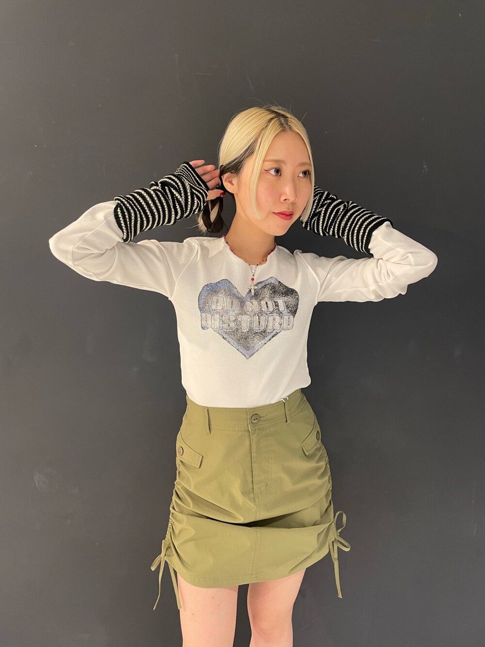 ホワイト系のTシャツ/カットソー、グリーン系のスカート、ブルー系のライダースジャケットを着用したレディースの秋コーディネートの6枚目の写真