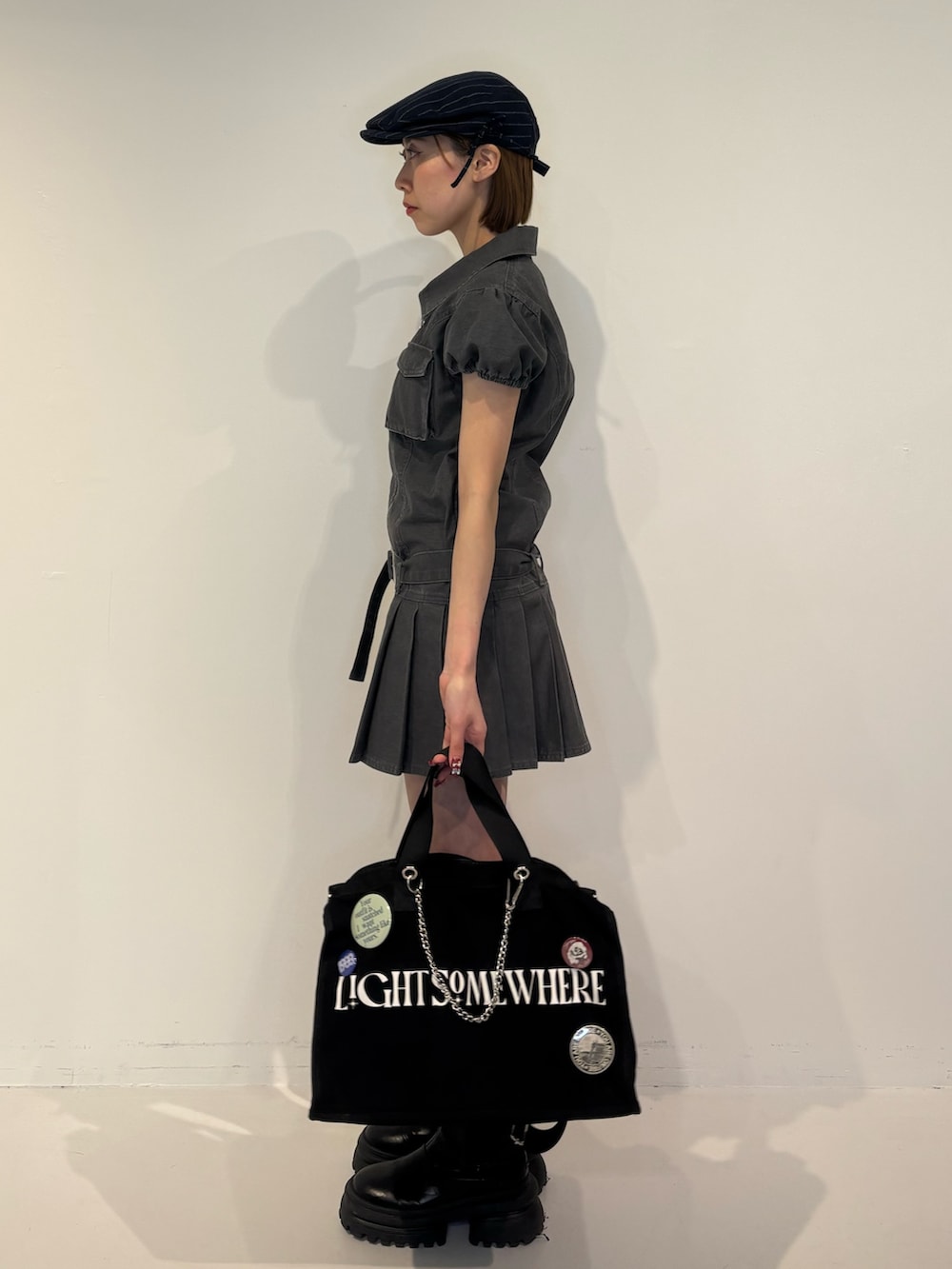 ブラック系のワンピース、ブラック系のボストンバッグ、ブルー系のハンチング/ベレー帽を着用したレディースの冬コーディネートの3枚目の写真