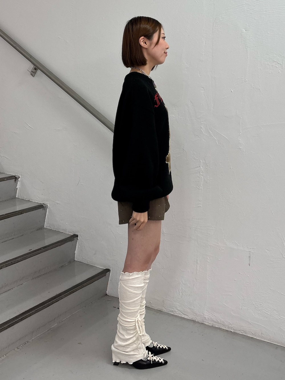 ブラック系のニット/セーター、ブラウン系のその他パンツ、ブラック系のパンプスを着用したレディースの秋コーディネートの3枚目の写真