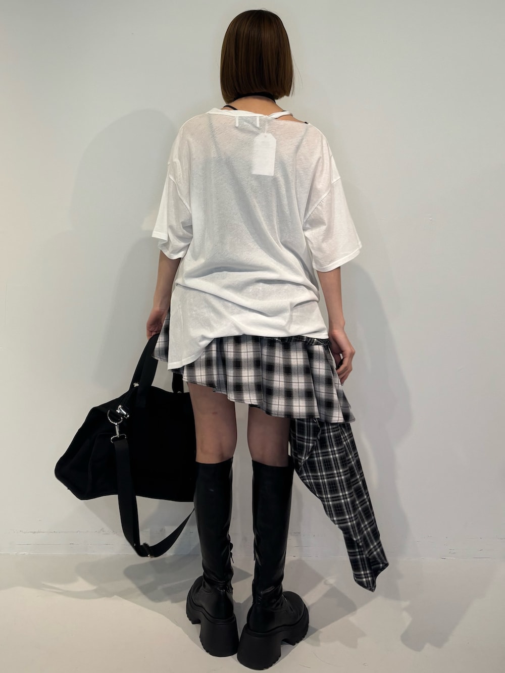 ブラック系のブーツ、ブラック系のボストンバッグ、ブラック系のスカートを着用したレディースの冬コーディネートの4枚目の写真