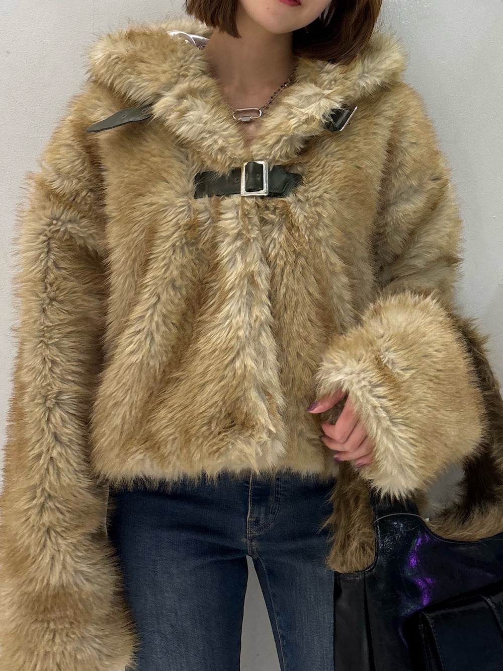 ブルー系のデニムパンツ、ブラック系のハンドバッグ、ブラック系のパンプスを着用したレディースの秋コーディネートの9枚目の写真