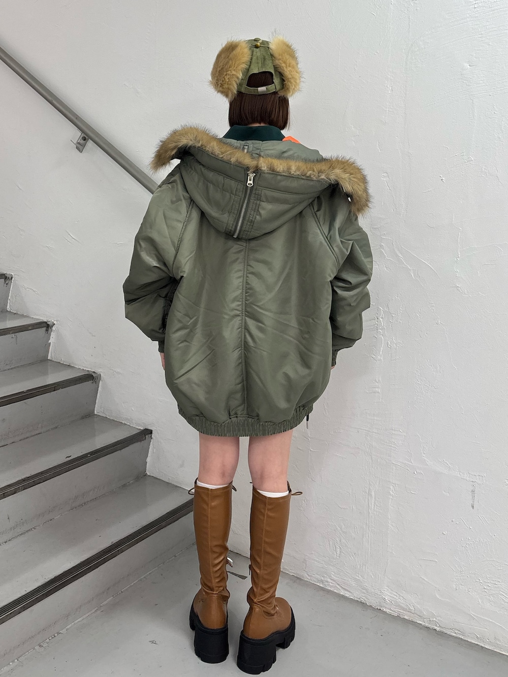 ホワイト系のTシャツ/カットソー、ホワイト系のスカート、グリーン系のブルゾンを着用したレディースの秋コーディネートの5枚目の写真