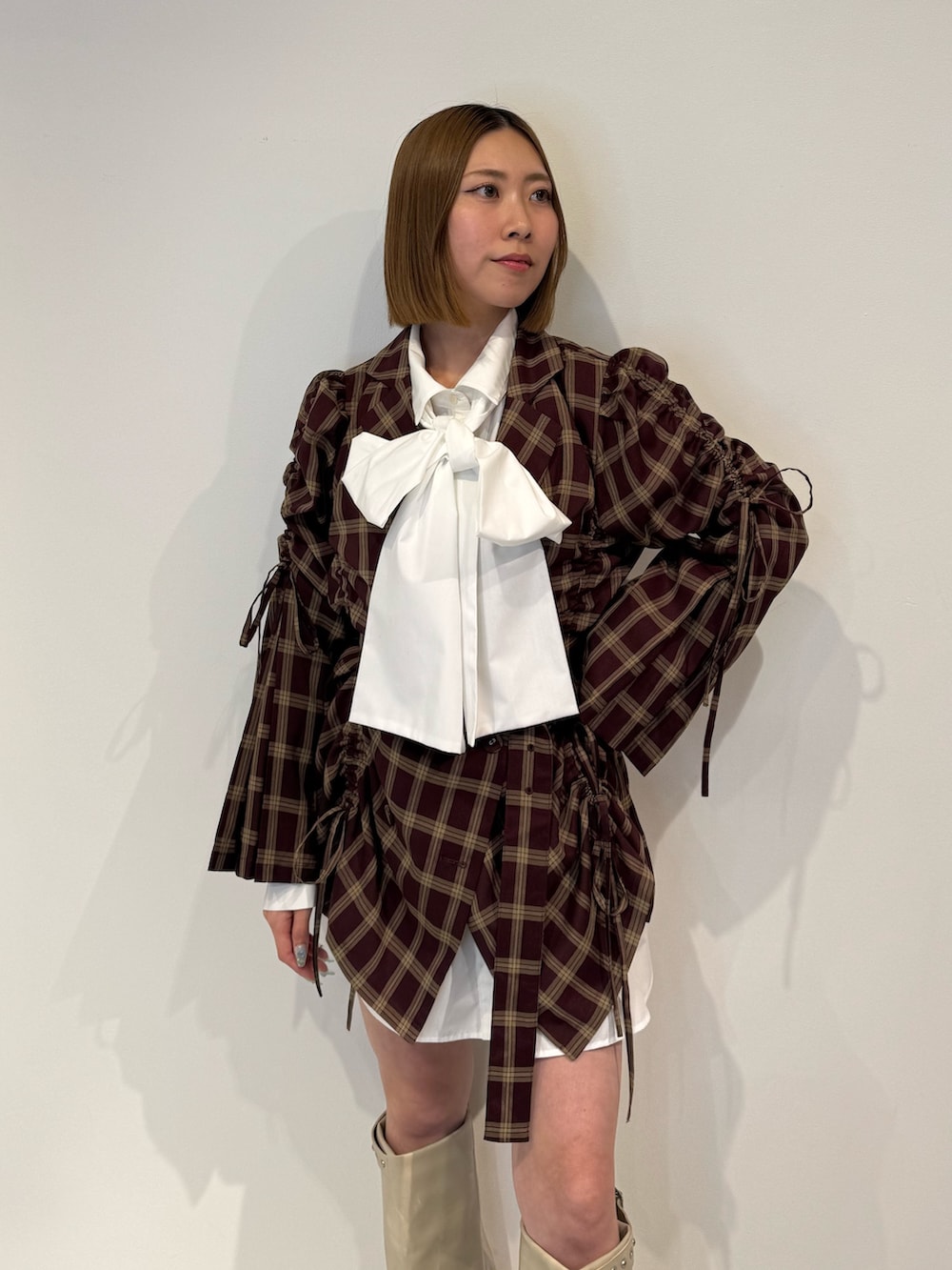 レッド系のワンピース、ホワイト系のブーツを着用したレディースの夏コーディネートの5枚目の写真