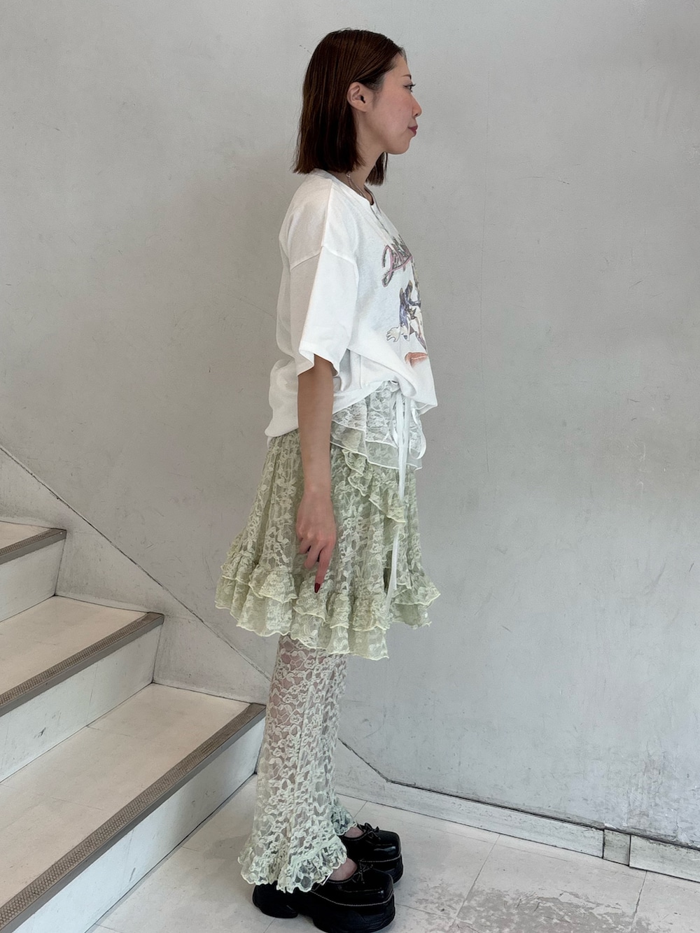 ホワイト系のTシャツ/カットソー、グリーン系のその他パンツ、ブラック系のスニーカーを着用したレディースの冬コーディネートの3枚目の写真