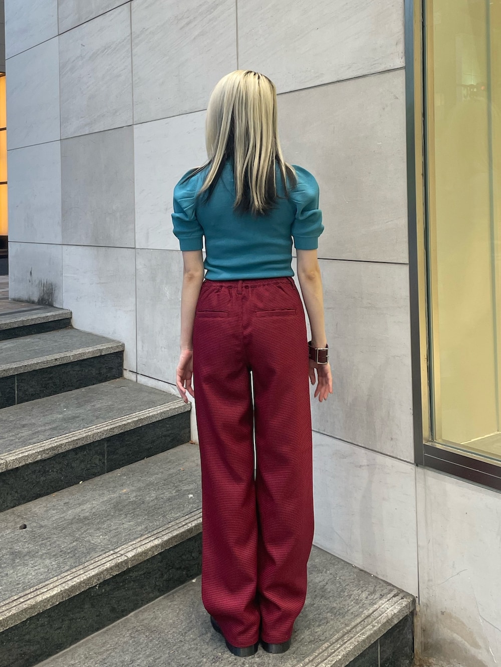 ブルー系のニット/セーター、レッド系のその他パンツ、レッド系のブレスレットを着用したレディースの夏コーディネートの3枚目の写真