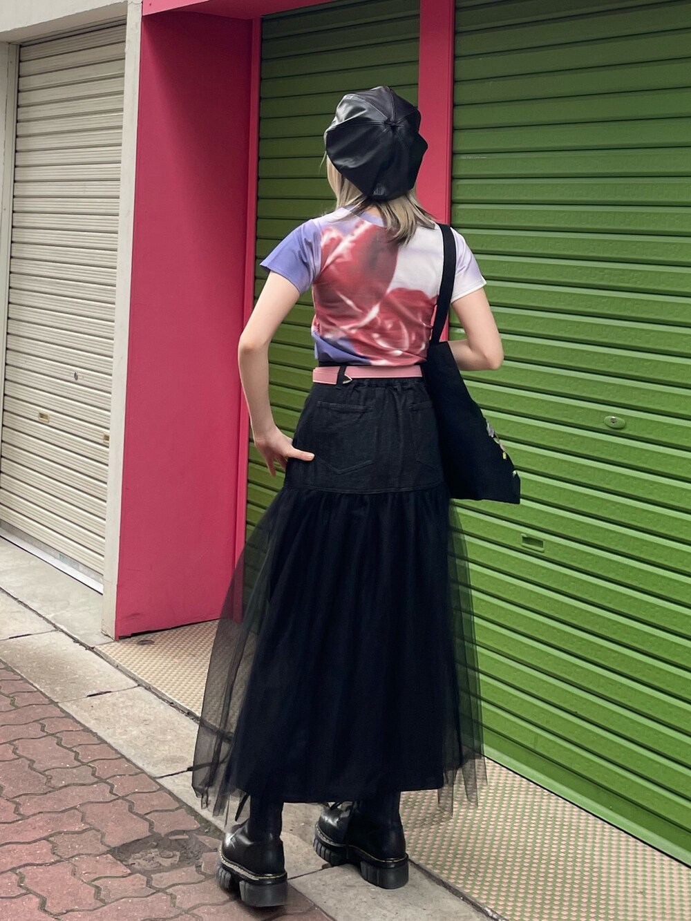 ブラック系のスカート、ブラック系のトートバッグ、パープル系のTシャツ/カットソーを着用したレディースの春コーディネートの4枚目の写真