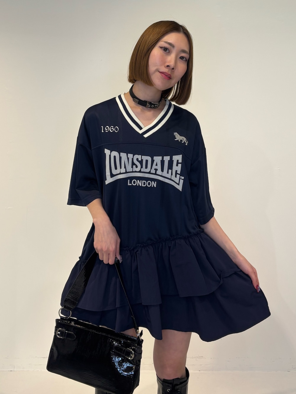 ブルー系のワンピース、ブラック系のハンドバッグ、ブラック系のブーツを着用したレディースの冬コーディネートの5枚目の写真