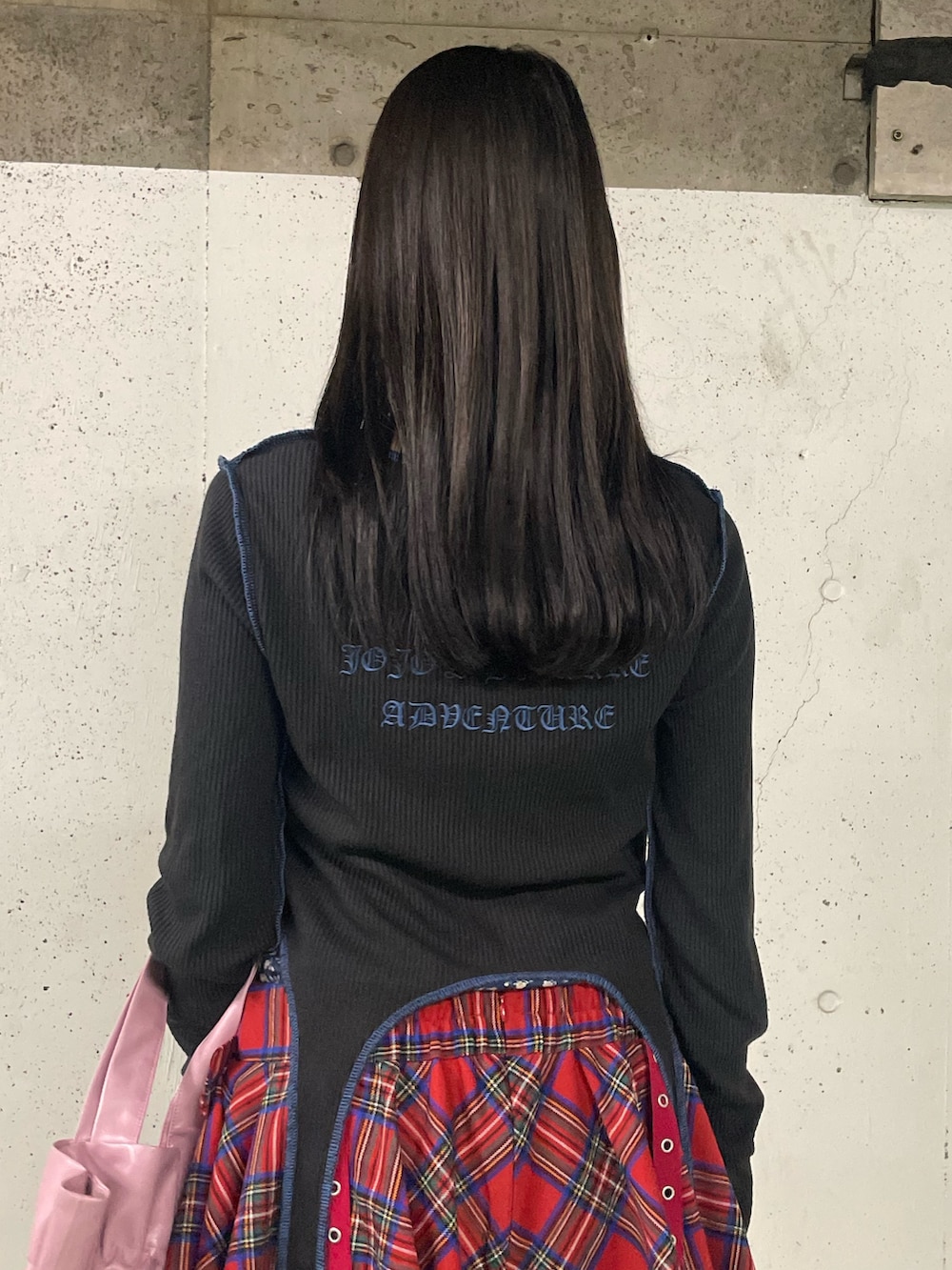 レッド系のスカート、ブラック系のブーツ、ブラック系のTシャツ/カットソーを着用したレディースの秋コーディネートの8枚目の写真