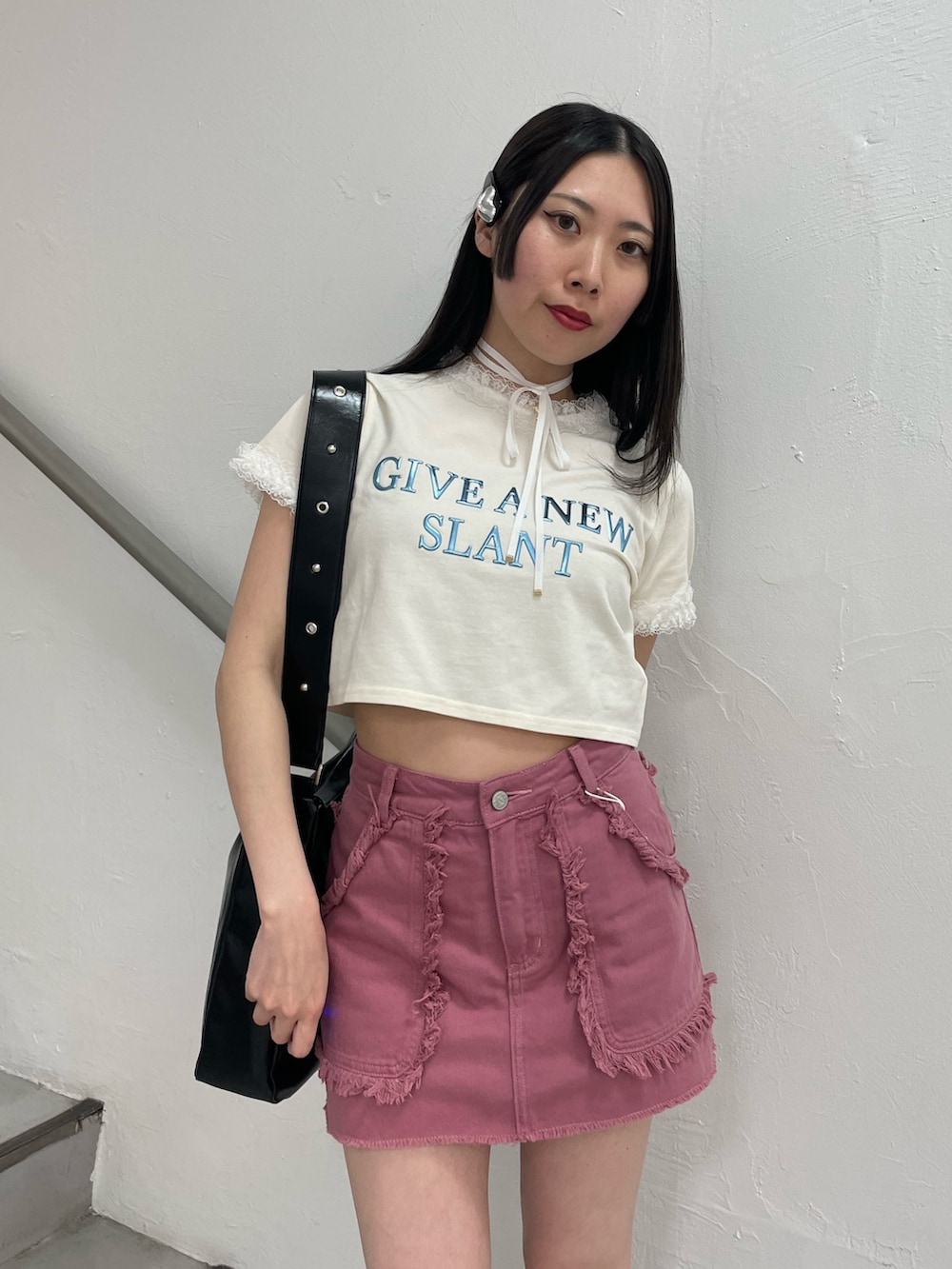ピンク系のスカート、ホワイト系のTシャツ/カットソー、ブラック系のショルダーバッグを着用したレディースの春コーディネートの6枚目の写真