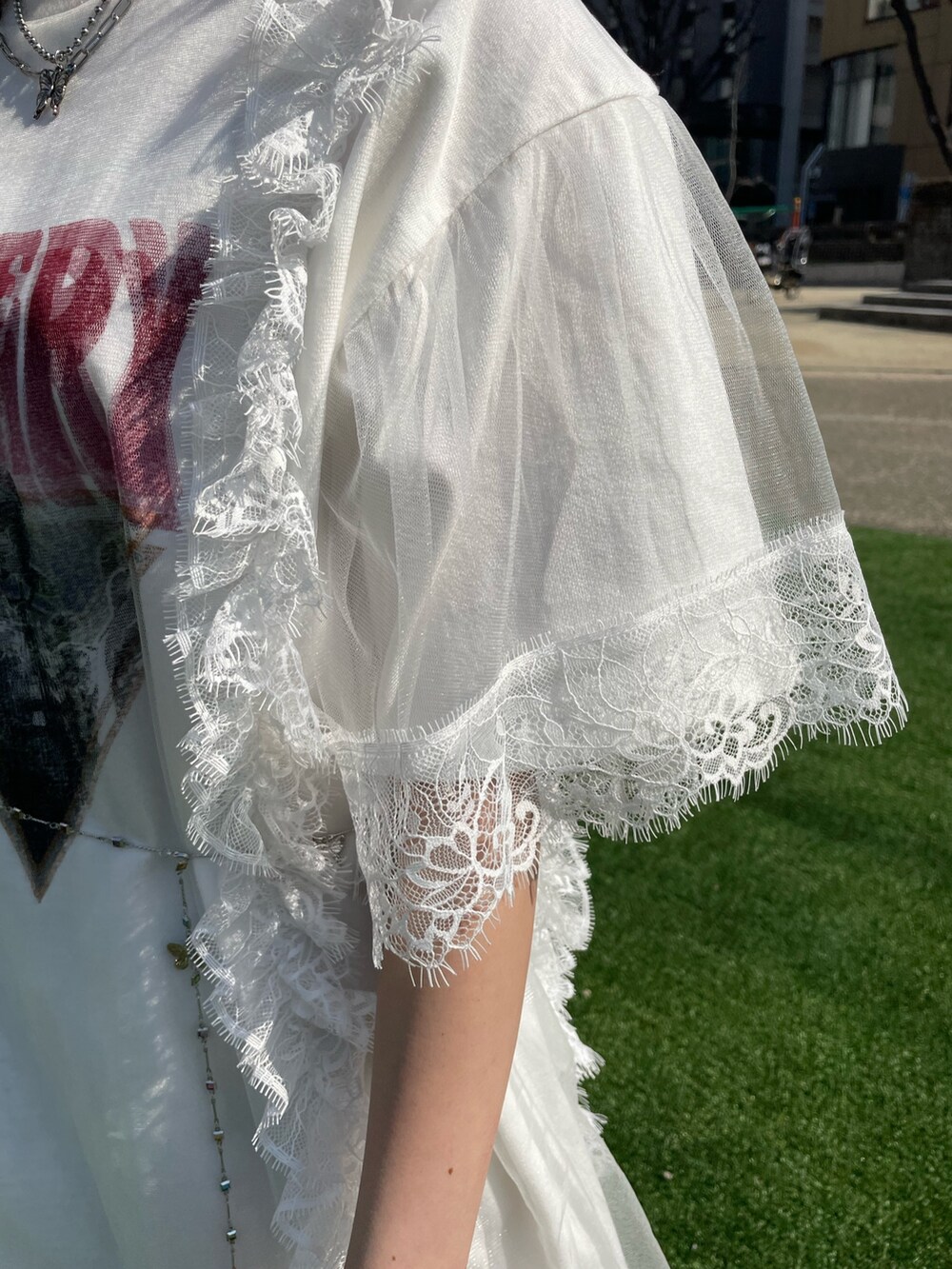 ホワイト系のワンピース、シルバー系のベルト、シルバー系のネックレスを着用したレディースの春コーディネートの8枚目の写真