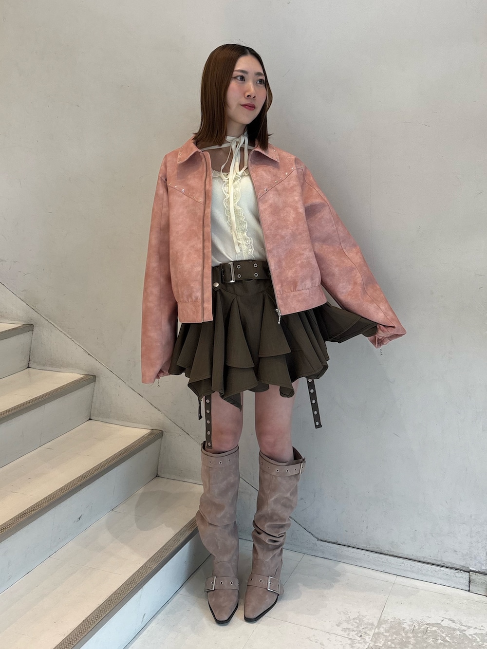 ベージュ系のスカート、ピンク系のブーツ、ピンク系のブルゾンを着用したレディースの冬コーディネートの2枚目の写真