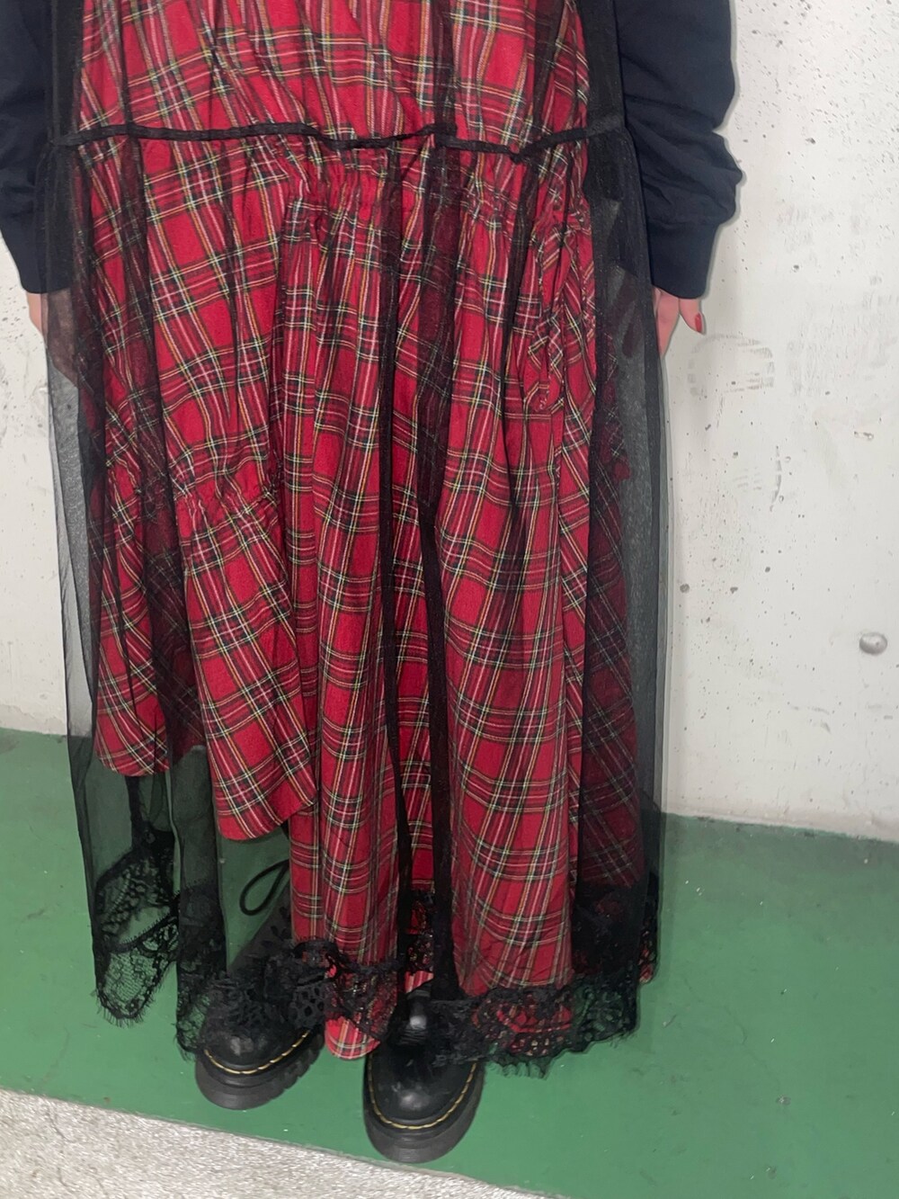 レッド系のスカート、ブラック系のワンピース、レッド系のネックレスを着用したレディースの冬コーディネートの7枚目の写真