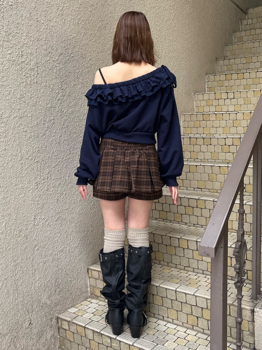 グレー系のスウェット、ブルー系のスカート、ブラック系のブーツを着用したレディースの冬コーディネートの4枚目の写真