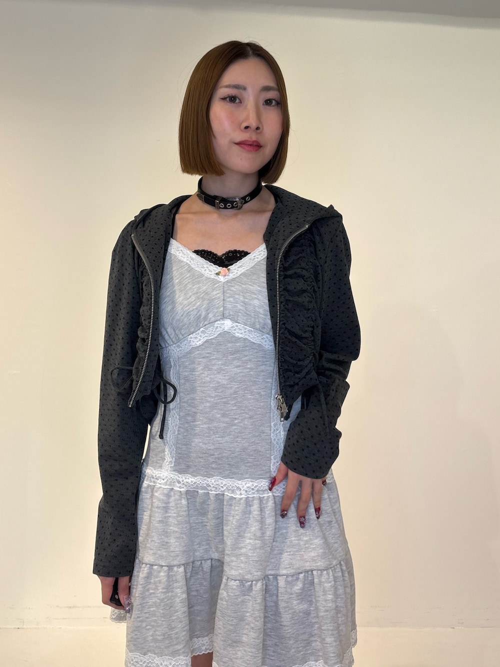 ブラック系のパーカー、グレー系のワンピース、ブラック系のブーツを着用したレディースの冬コーディネートの5枚目の写真