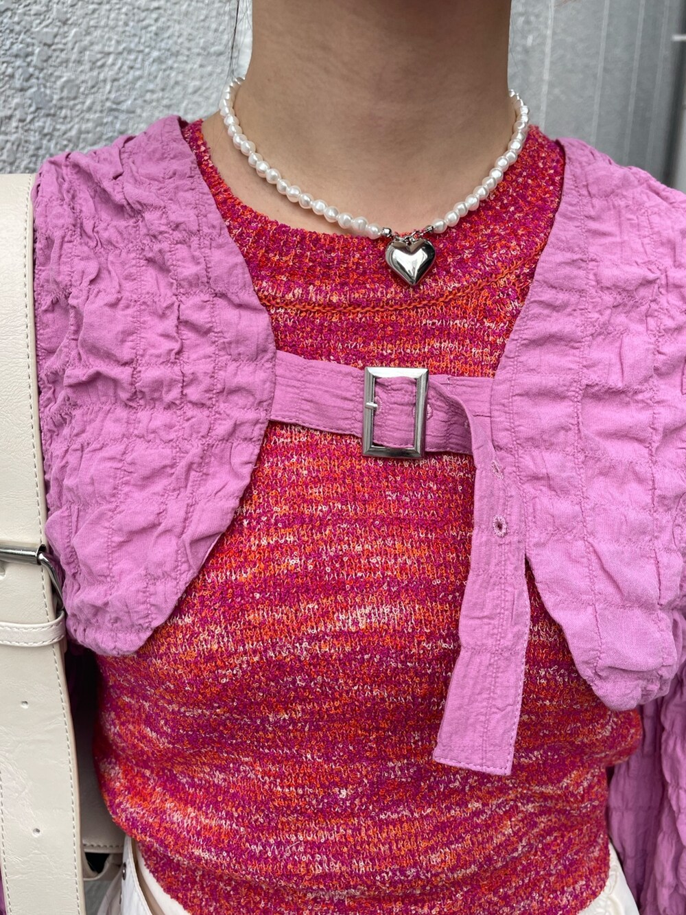 ホワイト系のその他パンツ、ピンク系のタンクトップ、ホワイト系のショルダーバッグを着用したレディースの春コーディネートの7枚目の写真