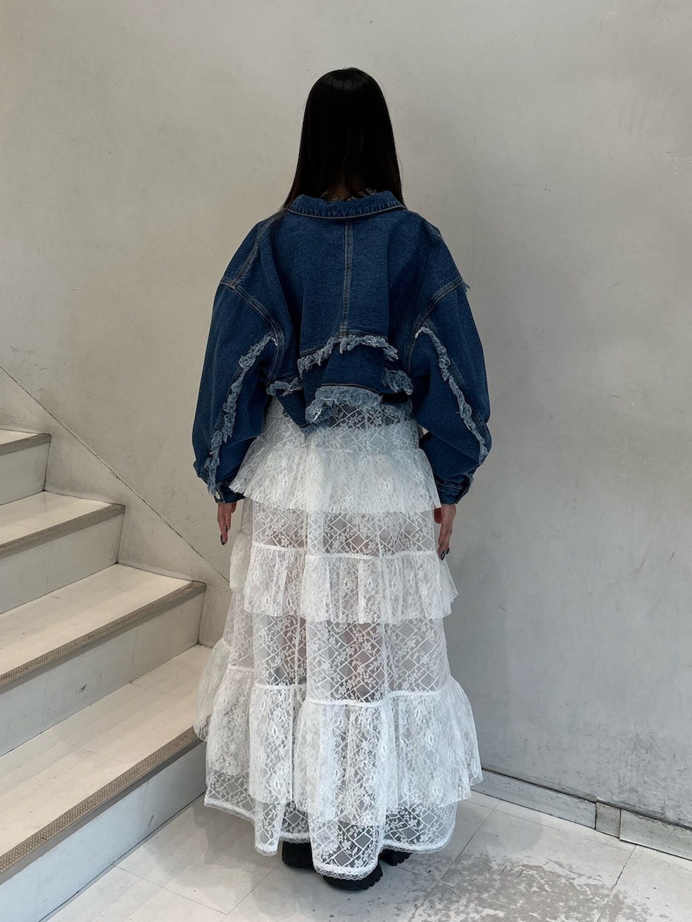 ホワイト系のワンピース、ブルー系のデニムジャケット、ブラック系のTシャツ/カットソーを着用したレディースの春コーディネートの5枚目の写真