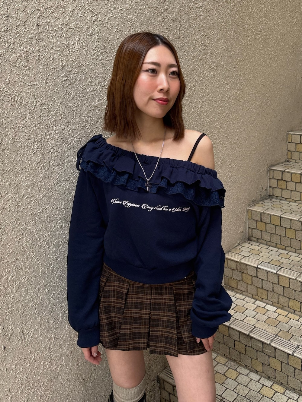 グレー系のスウェット、ブルー系のスカート、ブラック系のブーツを着用したレディースの冬コーディネートの5枚目の写真